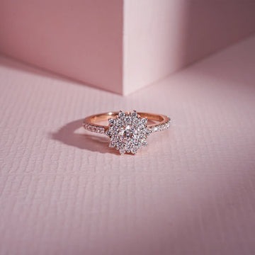 Elegant rose gold diamond halo ring on pink background with soft lighting